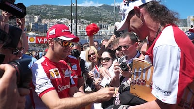 Ferrari driver Sebastien Vettel signs autographs in the pit line area of the Monaco Formula One Grand Prix in Monte Carlo on May 22, 2015. Boris Horvart / AFP