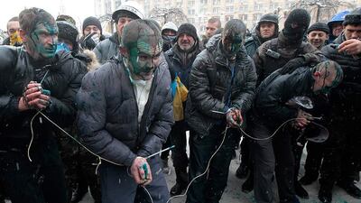 Pro-government hired thugs, referred to as "titushki" are captured by protesters in central Kiev. Anti-government protesters tied the suspected hired thugs, stained them with paint and then released them. Sergei Chuzavkov / AP Photo