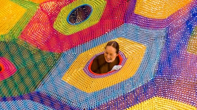 DUBAI, UNITED ARAB EMIRATES - AUG 3: 77 year old Japanese artist, Toshiko Horiuchi MacAdam, pops her head out of one of her net creations at a new play area in Dubai called OliOli. Toshiko creates nets made out of 800-1,000 kilos of nylon and weaves them into beautiful and inspiring art installations that are entirely interactive. (Photo by Reem Mohammed/The National) Reporter: Hala Khalaf Section: AC
