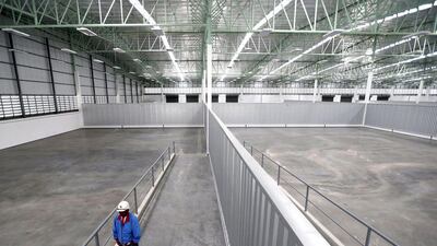 A worker walks in a recently built empty distribution warehouse in Udon Thani. Jorge Silva / Reuters