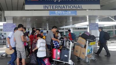 Passengers enter the Philippine Airlines passenger terminal at Manila airport on August 11, 2015. The carrier's parent company, PAL Holdings, reported its first-half net profit soared nearly ten-fold to 127 million USD, boosted by strong demand during the peak summer months. AFP PHOTO / Jay DIRECTO