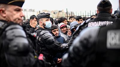 French gendarmes escort migrants queuing to board buses for temporary shelter during the evacuation of their makeshift camp that housed hundreds, mostly Afghan, in Paris. AFP