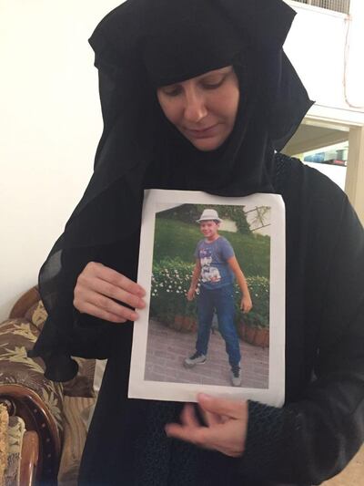 Tatiana Kruzina holds a picture of her son Athan. Haneen Dajani / The National
