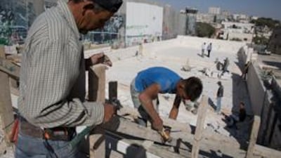 Construction workers finish a stage being constructed for the Pope's visit to the West Bank.