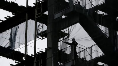 A worker adjusts the net at a construction site in Tokyo. Japan says revised data show its economy contracted at an annual rate of 7.1 per cent in April-June. The data released on Monday, September 8, 2014, showed business investment fell more than estimated earlier. Shuji Kajiyama / AP Photo