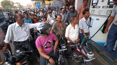 A crowd of motorcyclists queue at a petrol pump to fill up. A growing population and surging economy will drive global oil demand, says Citi. AFP