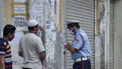 A Bahraini police officer instructs foreign workers on proper self-protection measures amid the Covid-19 pandemic in the old marketplace of the capital Manama. AFP