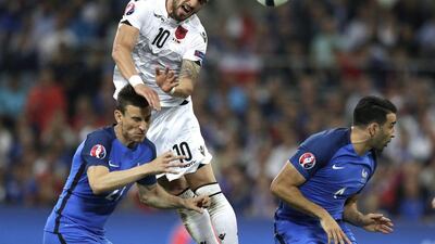 Albania's Armando Sadiku, top, heads the ball past France's Laurent Koscielny, left, and Adel Rami. Ariel Schalit / AP Photo