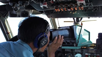 A military personnel member scans for wreckage from the Malaysian Airlines Boeing 777 along the Vietnamese seaboard on a Vietnamese Air Force aircraft. Thanh Nien Newspaper / AFP Photo / March 8
