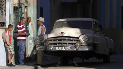 Cubans talk near a broken car in Havana. The 1959 law that Fidel Castro implemented also banned the import of parts, which meant repairs of American cars and replacements often had ingenious and creative qualities. Enrique De La Osa / Reuters