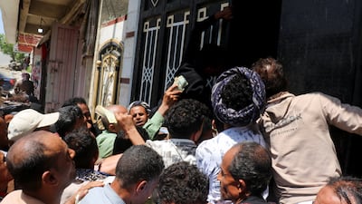People crowd outside a shop to buy sacks of wheat flour as clashes between Iran-aligned Houthi fighters and government forces continue, in Taiz, Yemen. Reuters