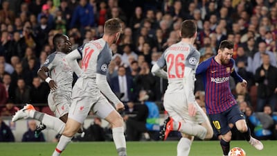 Barcelona's Lionel Messi, right, plays the ball past Liverpool's Andy Robertson, second right, Jordan Henderson, second left, and Sadio Mane. Emilio Morenatti / AP Photo