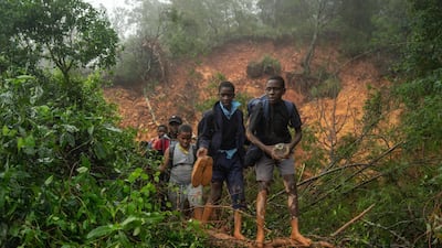 School students of St. Charles Luanga, rescued by members of the Zimbabwe Military, walk past a mudslide, covering a major road at Skyline junction in Chimanimani, Manicaland Province, Zimbabwe. AFP
