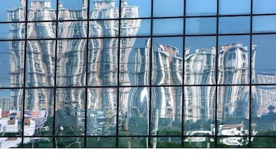 Luxury residential apartments are reflected in the glass of a building in Gurgaon, 30kms south of Delhi. Manan Vatsyayana / AFP