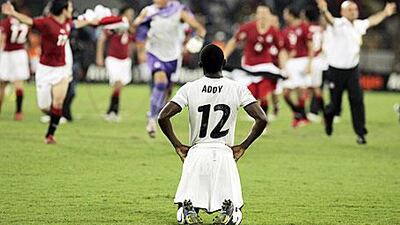 Ghana's Lee Addy slumps to his knees as Egypt's players celebrate victory in the final.