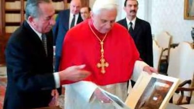 Pope Benedict XVI looks at a book he received as a gift from Cypriot President Tassos Papadopoulos, left, during a private audience at the Vatican in November.