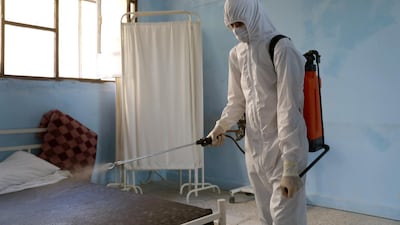 Medical personnel spray disinfectants at a community treatment centre for possible Covid-19 patients in Ariha city, south Idlib, Syria. EPA