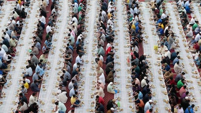 People sit together to break their fast in the parking area near Al Ghubaiba Bus Station in Bur Dubai. Pawan Singh / The National