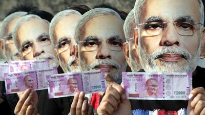 Indian girls wearing Narendra Modi masks in Jammu, Kashmir, India, hold new currency notes in support of a ban on old high denomination currency notes. Jaipal Singh / EPA