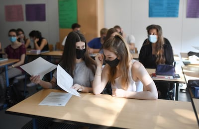 Students of the eleventh grade sit with face masks in a classroom of the Phoenix high school in Dortmund, western Germany, on 12 August. Ina Fassbender/ AFP