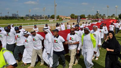 Most people carrying a flag banner: The UAE broke the world record of most people carrying a flag banner in 2015 with a participation of 2139 Emirati students from the Abu Dhabi Vocational Education and Training Institute (ADVETI), and incorporation with Abu Dhabi Equestrian Club. Marking the celebrations of the 43rd UAE National Day, thousands of Emirati students walked a span of 230 meters carrying the UAE flag, measuring two kilometres long and five meters wide, at the Abu Dhabi Equestrian Club. Courtesy Abu Dhabi Vocational Education and Training Institute