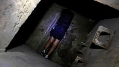A protester tries to escape through a sewage tunnel inside the Hong Kong Polytechnic University campus during protests in Hong Kong. REUTERS