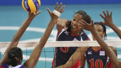 Tayyiba Haneef-Park spikes against Nancy Carrillo, left, as the USA's Kimberly Glass looks on during their women's volleyball semi-finals match at the Beijing 2008 Olympics.