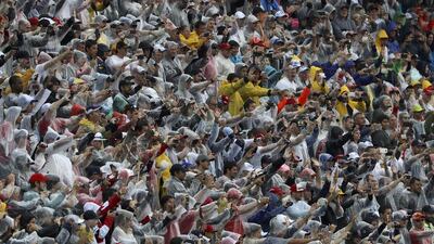 Fans cheer in the rain during the race. Paulo Whitaker / Reuters