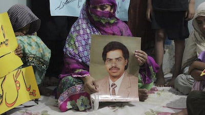 Safia Bano displays a picture of her husband Imdad Ali, a schizophrenic who has been on death row for the murder of a cleric in 2001, as she sits with other family members in Burewala, in central Pakistan. Asghar Ali / AP Photo / September 18, 2016