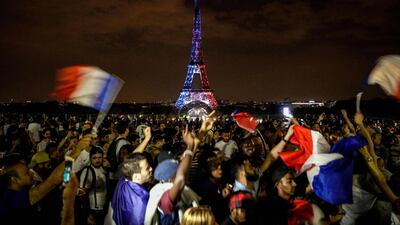 This picture taken from Trocadero on July 15, 2018 shows the Eiffel Tower illuminated in French national colors during celebrations after the Russia 2018 World Cup final football match between France and Croatia, on the Champs-Elysees avenue in Paris. / AFP / Geoffroy VAN DER HASSELT