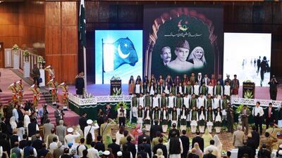 Pakistan's President Mamnoon Hussain (top L) stands under Pakistan's national flag while listening the national anthem along with others during a ceremony to mark the country's Independence Day in Islamabad on August 14, 2017. Pakistan’s Independence Day, which is annually held on August 14, celebrates the country’s independence from the British rule on that date in 1947. / AFP PHOTO / AAMIR QURESHI