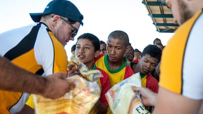 Sean Carey hands out Dubai Hurricanes playing kit to junior players from the USI Ikopa team in Antananarivo, at a tournament organised by the Air Seychelles Mike Ballard Foundation Conquistadors. Photo by Rafalia Henitsoa