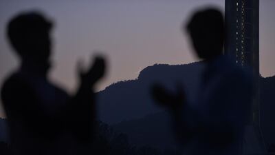 Pakistani Muslims raise their hands in prayer after viewing the new Crescent moon (C) above the Margala Hills to mark the beginning of the Islamic holy month of Ramadan in Islamabad. Aamir Oureshi / AFP