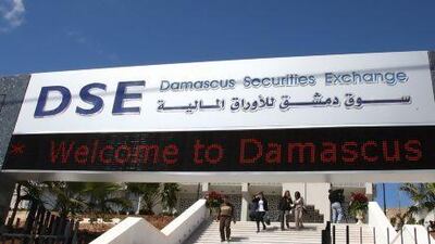People walk at the entrance of the Damascus Securities Exchange. Khaled al-Hariri / Reuters