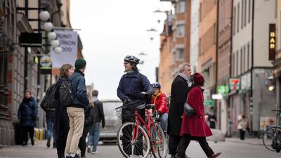 People talk on a street in the Sodermalm district of Stockholm, Sweden, as the spread of the coronavirus continues in the country, on April 1, 2020. Reuters