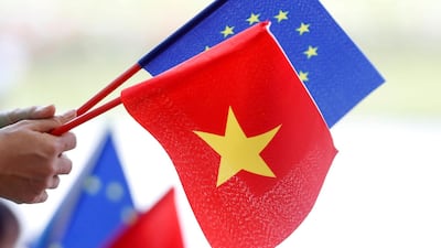EU and Vietnamese flags are seen during the signing ceremony of a trade agreement in Hanoi last year. On Monday, the deal was ratified by the Vietnam National Assembly. Reuters