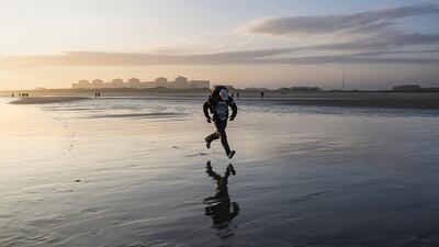 A migrant runs to board a dinghy to try to cross the English Channel, at Gravelines, northern France. AFP