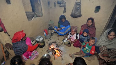 In a picture taken on February 9, 2012, Chandra Bahadur Dangi, a 72-year-old Nepali who claims to be the world's shortest man at 56 centimetres (22 inches) in height, has dinner with relatives at his home village in Reemkholi village, Dang district, some 540 kilometres southwest of Kathmandu. Pilloried by neighbours, laughed at in freakshows and spurned by the women he admired from afar, Chandra Bahadur Dangi has always seen his tiny stature as a curse. But the 72-year-old Nepali, who claims to stand at just 56 centimetres (22 inches), is on the brink of life change as significant as a lottery win as experts prepare to test his claim to be the shortest man in history. AFP PHOTO/Prakash MATHEMA *** Local Caption *** 864213-01-08.jpg