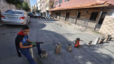 A Palestinian boy with a toy gun in Jenin, in the occupied West Bank, where real guns are causing strife. AFP