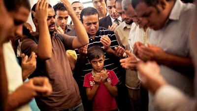 A son of the late Ammar Badie prays during his father's funeral in al-Hamed mosque in Cairo's Katameya district. Manu Brabo / AP Photo