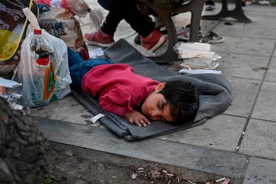 An Afghan child rests by her family's belongings in Moria camp on the Greek island of Lesbos. AFP