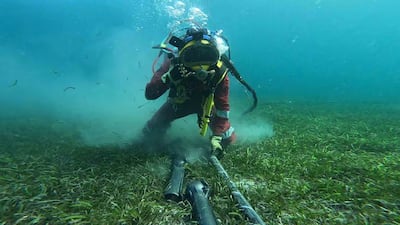 A scuba diver installs an articulated pipe around an undersea cable. Photo: International Cable Protection Committee