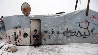 A boy stands at the door of his tent. Hussein Malla / AP Photo