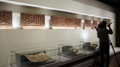 A cameraman films part of thirteen fragments of an epigraphic fresco from India dating back to the 12th century. Francois Guillot/AFP