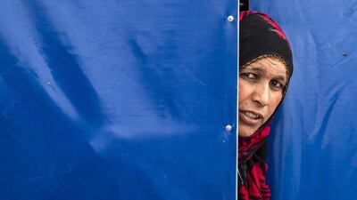 A Syrian woman peeps from behind a tent at the Washukanni camp in the mainly Kurdish northeastern Syrian province of Hasakeh. AFP