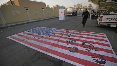 A mock US flag is laid on the ground for cars to drive on in the Iraqi capital Baghdad. AFP
