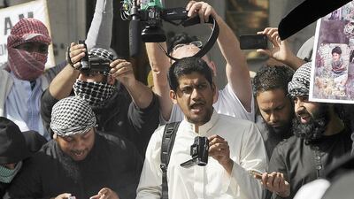 A file picture shows a man identified by local media as Siddharta Dhar, centre in white, as he takes part in a demonstration outside the US embassy in central London, September 11, 2011. Dhar is widely identified by local media as the masked figure with a British accent in the latest video distributed by ISIL which shows the execution of 5 men. Paul Hackett/Reuters