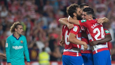 Granada players celebrate their win at the end of the La Liga match against Barcelona. Granada won 2-0 at Nuevo Los Carmenes Stadium to go top of the table. AFP