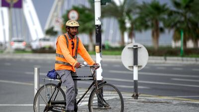 A worker on his way to work at the Al Bandar area on a gloomy day. Victor Besa / The National