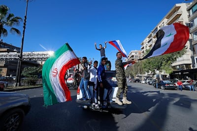Syrian government supporters wave Syrian, Iranian and Russian flags as they chant slogans against US President Donald Trump during demonstrations following a wave of US, British and French military strikes to punish President Bashar Al Assad for a chemical attack against civilians, in Damascus, Syria, on April 14, Hassan Ammar / AP